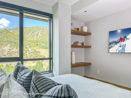 a bedroom with a bed and a large window