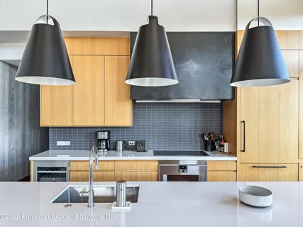 a kitchen with kitchen island granite countertop a sink and a stove