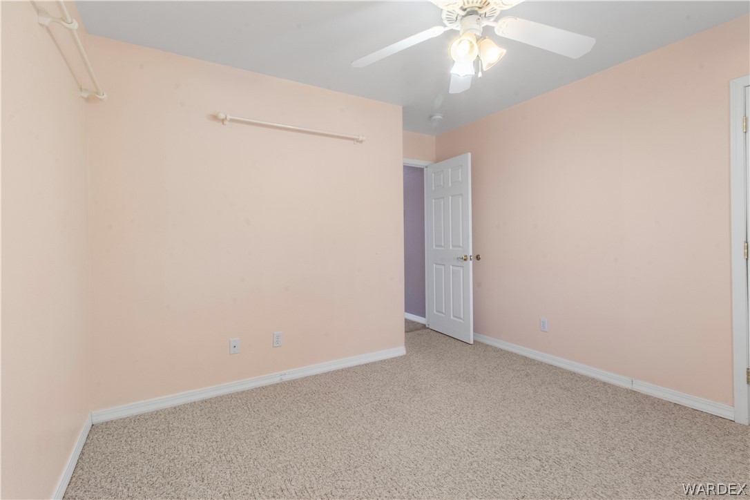 2158 Ranch Road Kingman, AZ 86401 - Photo 23 of 48 an empty room with a ceiling fan and a window