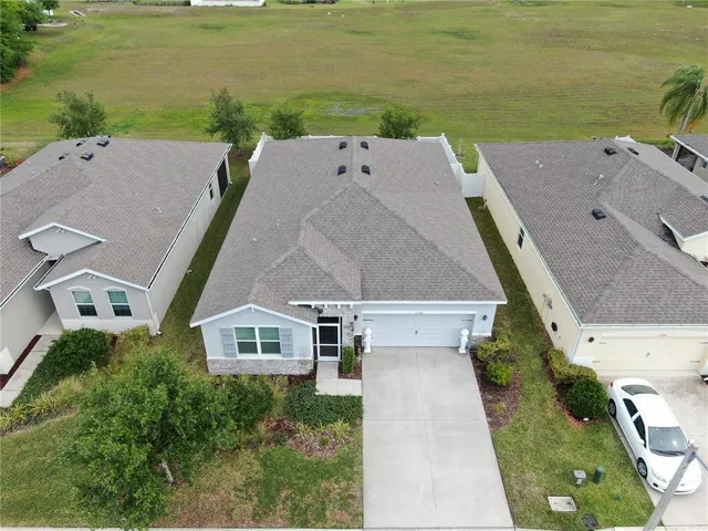 an aerial view of ocean and residential houses with outdoor space