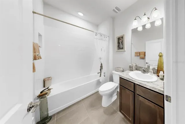 a bathroom with a toilet a sink a mirror a bathtub and vanity