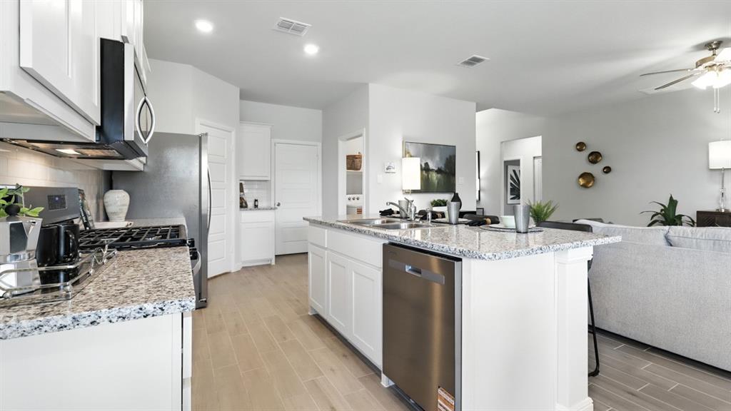 657 Harvey Street Grandview, TX 76050 - Photo 5 of 40 a kitchen with stainless steel appliances kitchen island granite countertop a sink stove and refrigerator
