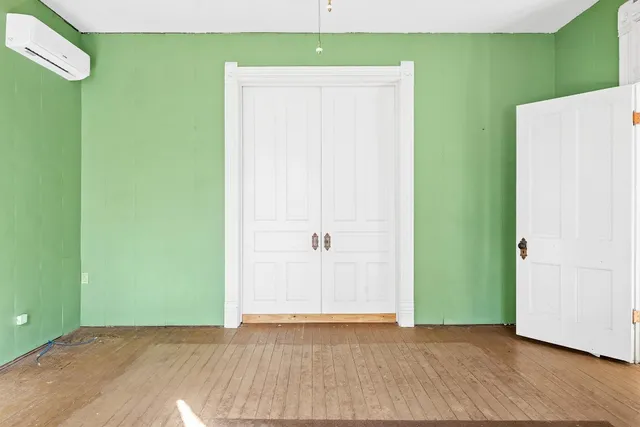 a view of an empty room with wooden floor and entryway