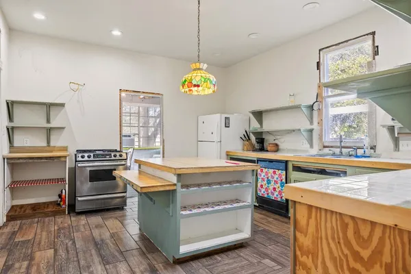 a kitchen that has a lot of cabinets in it and wooden floor