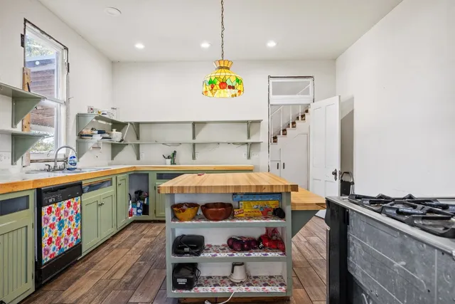 a utility room with stainless steel appliances a stove a sink dishwasher and cabinets