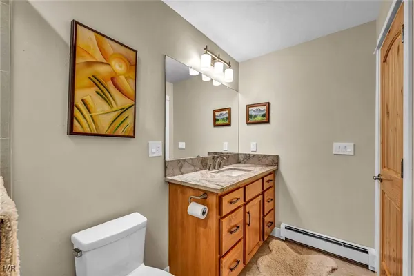 a bathroom with a granite countertop sink toilet and shower