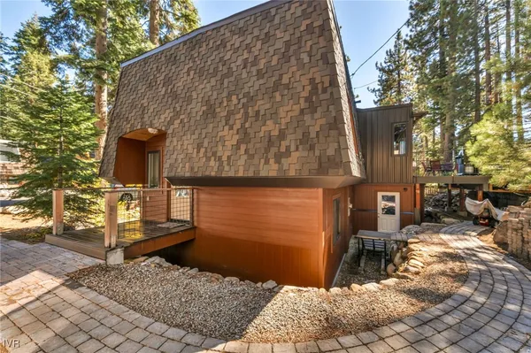 a brick house with a large windows and wooden fence