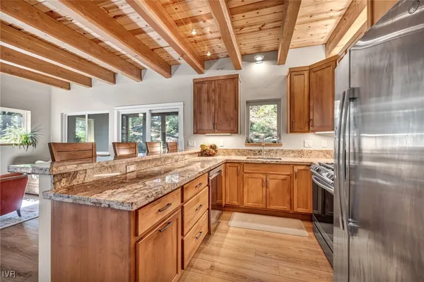 a large kitchen with stainless steel appliances granite countertop a sink window and refrigerator