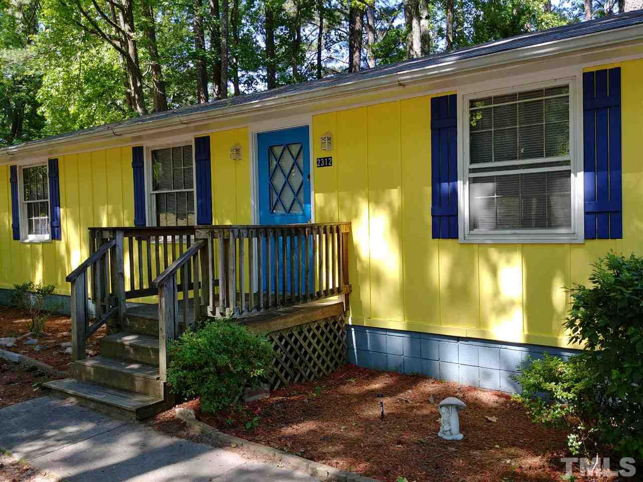 a view of a house with a small yard and wooden floor and fence