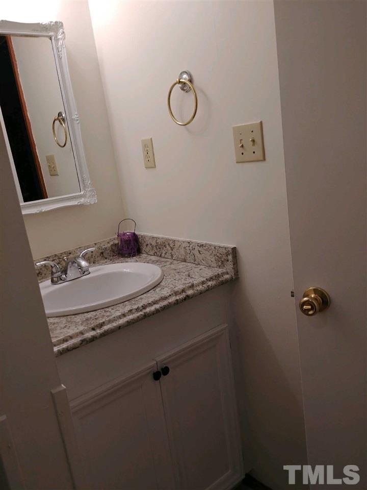 2312 Creech Road Raleigh, NC 27610 - Photo 11 of 11 a bathroom with a granite countertop sink and mirror