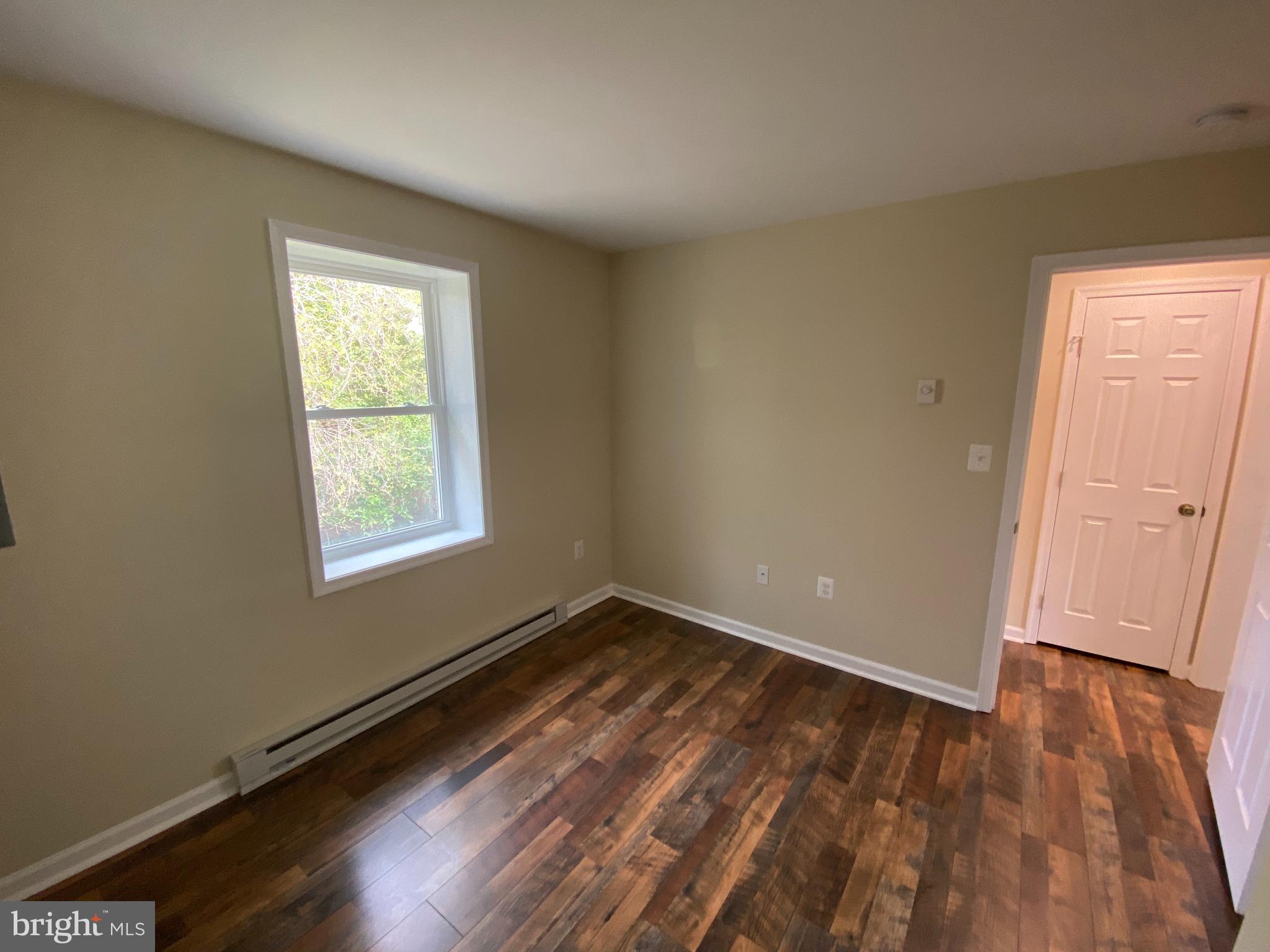114 Loch Ln Drive, Unit 5 Louisa, VA 23093 - Photo 13 of 17 an empty room with wooden floor and windows