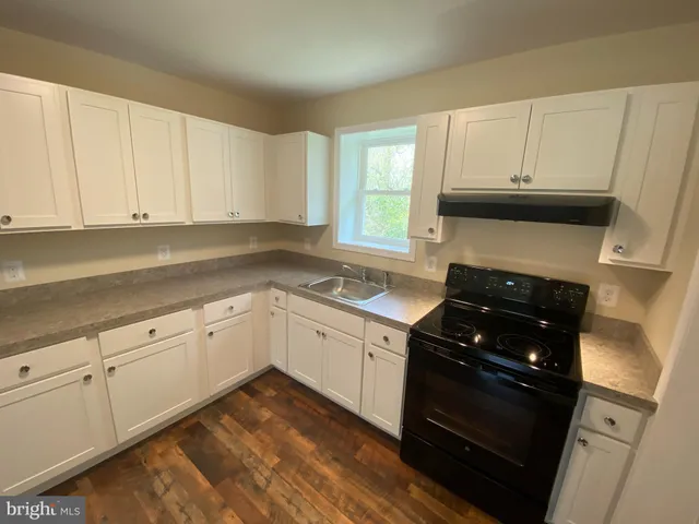 a kitchen with granite countertop white cabinets and appliances