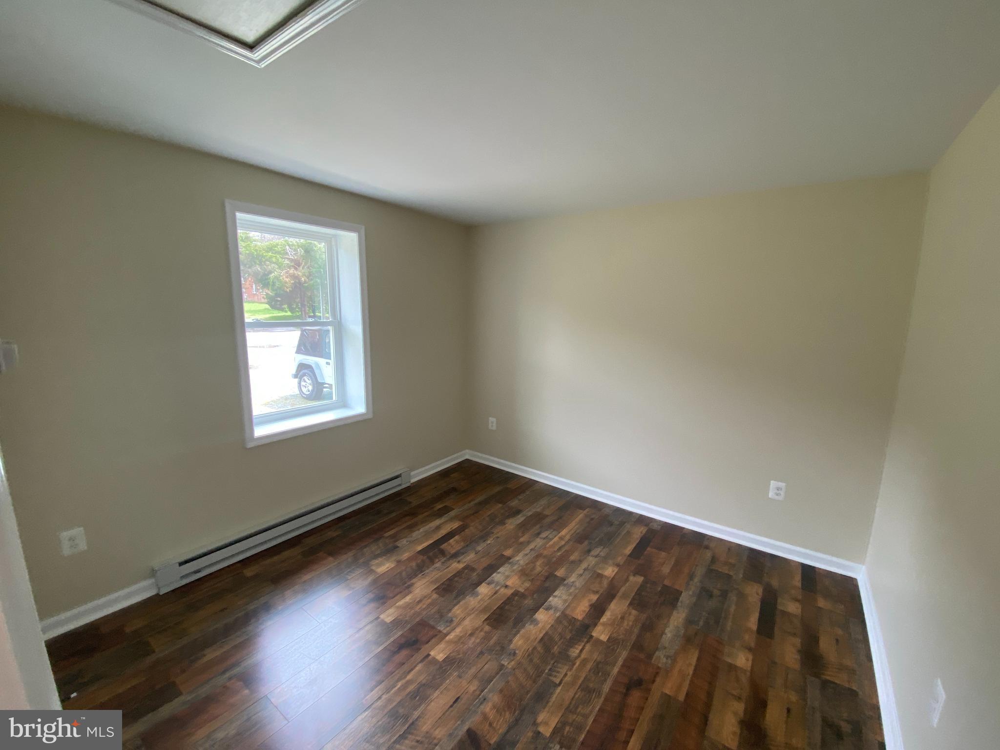 114 Loch Ln Drive, Unit 5 Louisa, VA 23093 - Photo 6 of 17 an empty room with wooden floor and windows