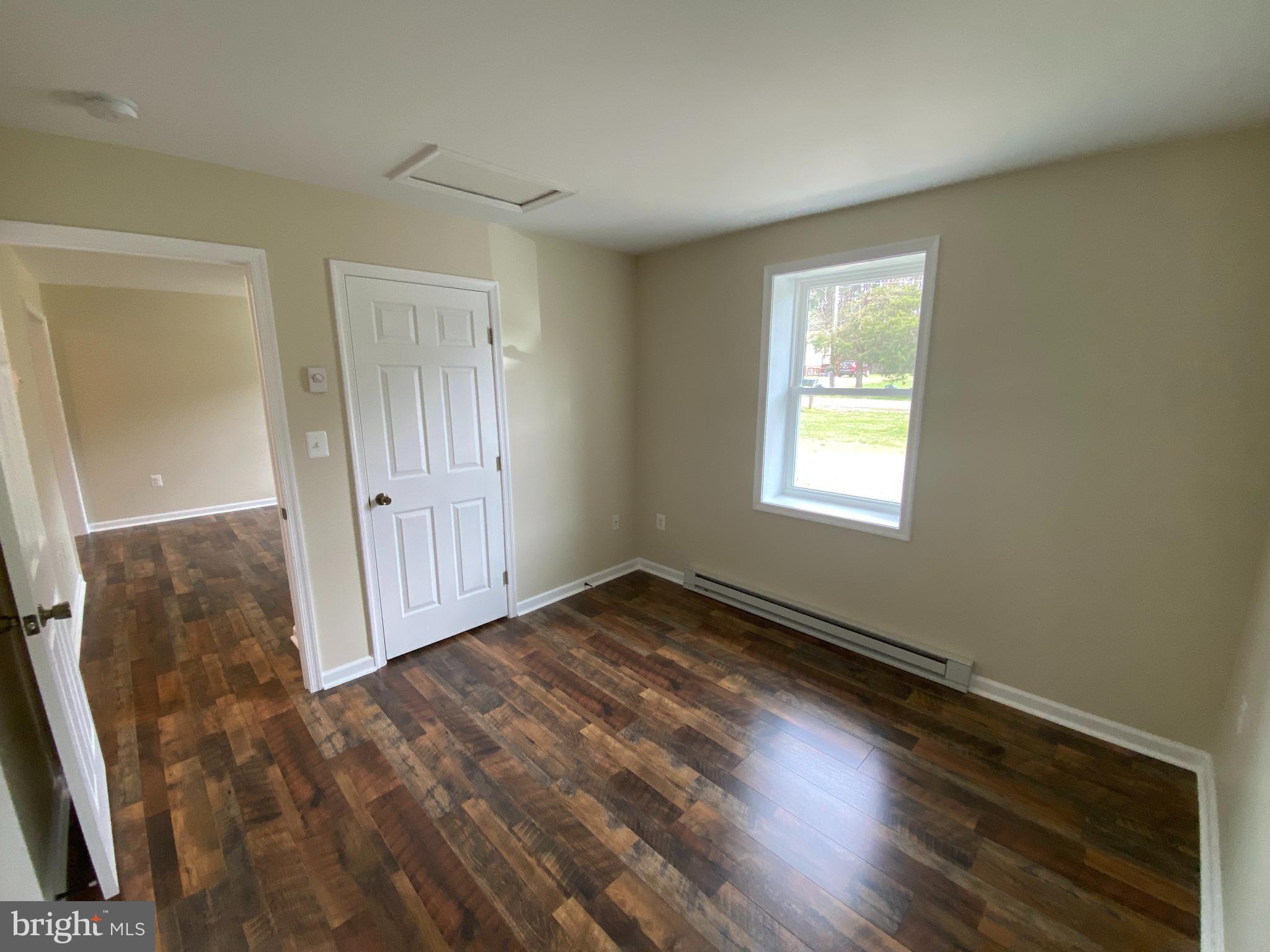 114 Loch Ln Drive, Unit 5 Louisa, VA 23093 - Photo 7 of 17 an empty room with wooden floor and windows