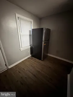 a view of empty room with wooden floor and cabinet