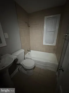 a bathroom with a toilet a sink and bathtub