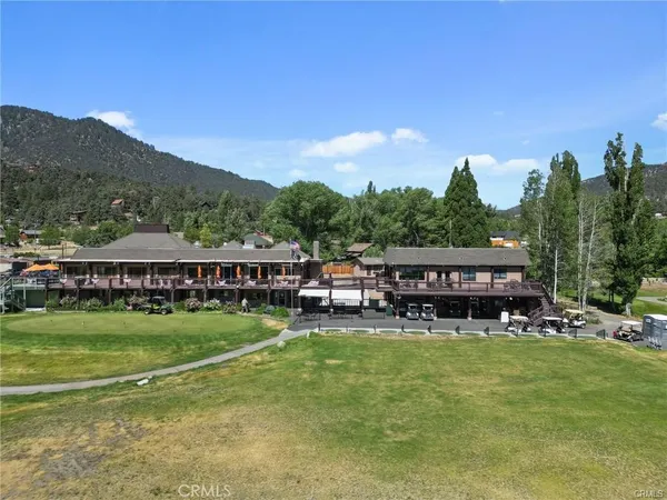 a view of a house with a big yard and sitting area