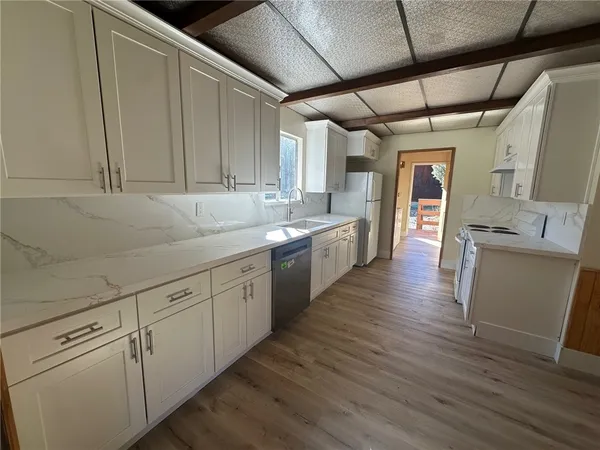 a kitchen with white cabinets and sink