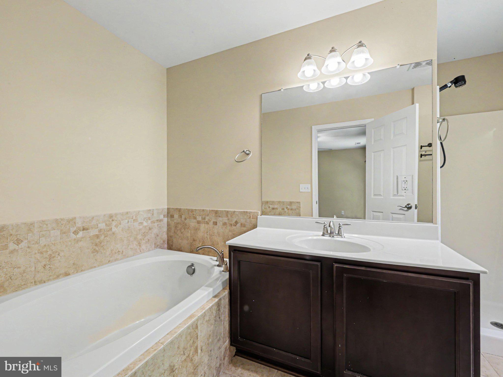 9811 Catharpin Road Spotsylvania, VA 22551 - Photo 25 of 30 a bathroom with a tub sink and mirror