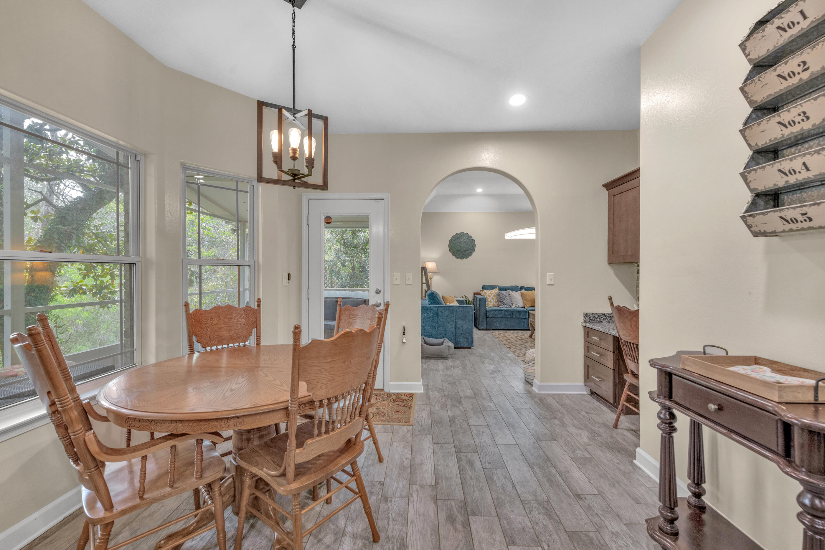 4475 Woodbridge Road Niceville, FL 32578 - Photo 17 of 49 a view of a dining room with furniture a chandelier and wooden floor