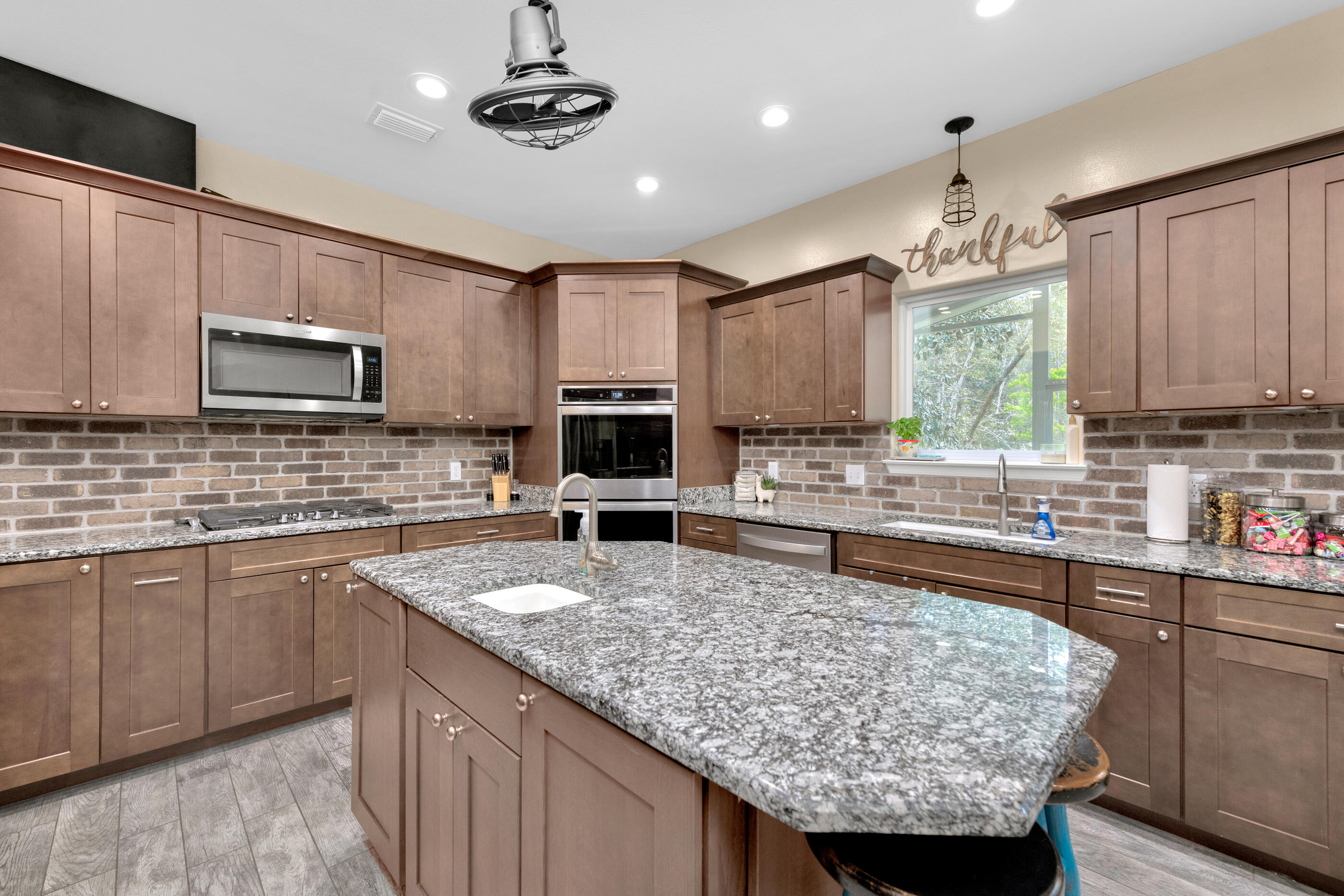 4475 Woodbridge Road Niceville, FL 32578 - Photo 10 of 49 a kitchen with kitchen island granite countertop a sink counter top space appliances and cabinets