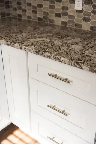 a kitchen with granite countertop white cabinets and white appliances