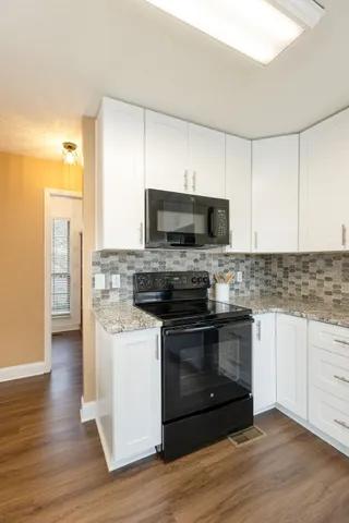 a large bed sitting in a bedroom next to a window and a chandelier