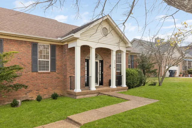 a front view of a house with yard and green space