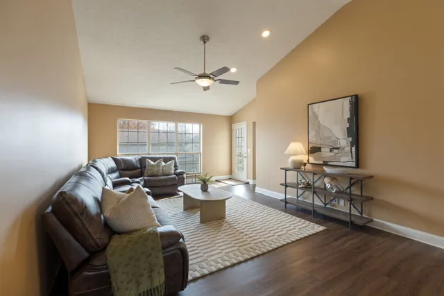 a living room with furniture and a wooden floor