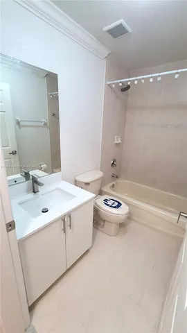 a bathroom with a sink and mirror with bathtub