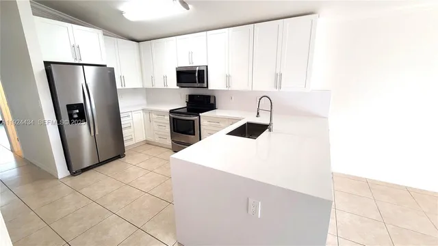 a kitchen with stainless steel appliances a refrigerator sink and microwave