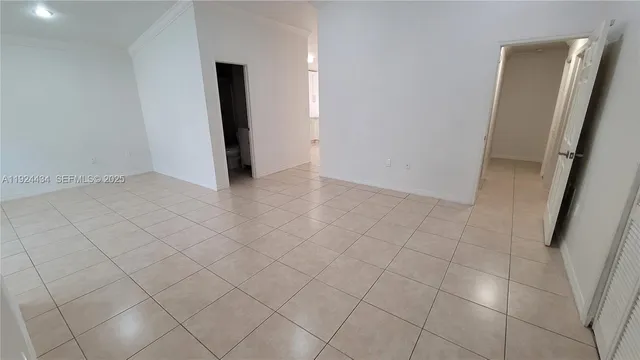 an empty room with wooden floor and mirror
