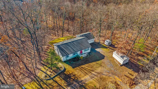 a front view of house with yard and trees in the background