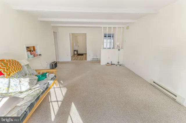 an empty room with a bathroom and mirror