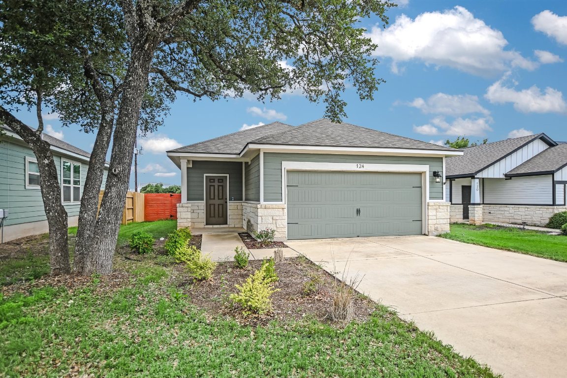 124 Ancellotta Way Leander, TX 78641 - Photo 1 of 20 View of front of home with concrete driveway, a garage, stone siding, and roof with shingles
