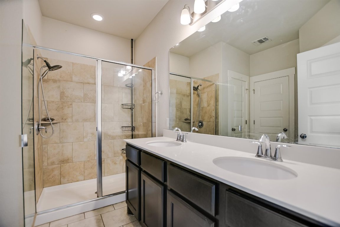 124 Ancellotta Way Leander, TX 78641 - Photo 13 of 20 Full bathroom with double vanity, a stall shower, and tile patterned floors