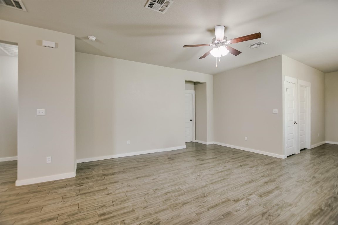 124 Ancellotta Way Leander, TX 78641 - Photo 7 of 20 Spare room featuring ceiling fan, wood finished floors, and a smoke detector
