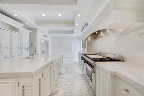 a kitchen with granite countertop a sink a stove and a refrigerator
