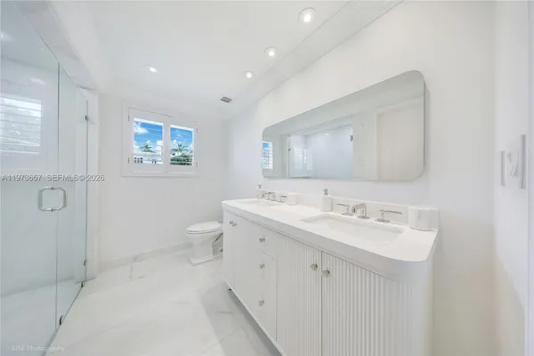 a spacious bathroom with a double vanity sink mirror and toilet