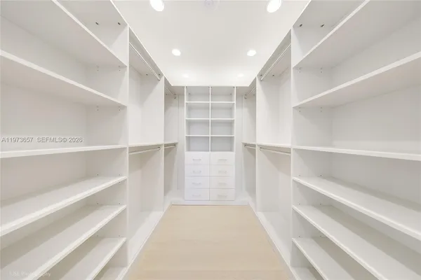 a view of walk in closet with empty racks