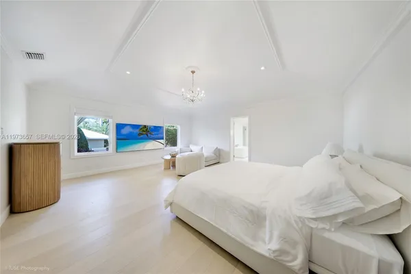 a bedroom with a large bed and a potted plant