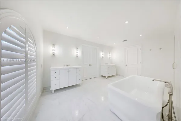 a spacious bedroom with a bed and a painting on the wall