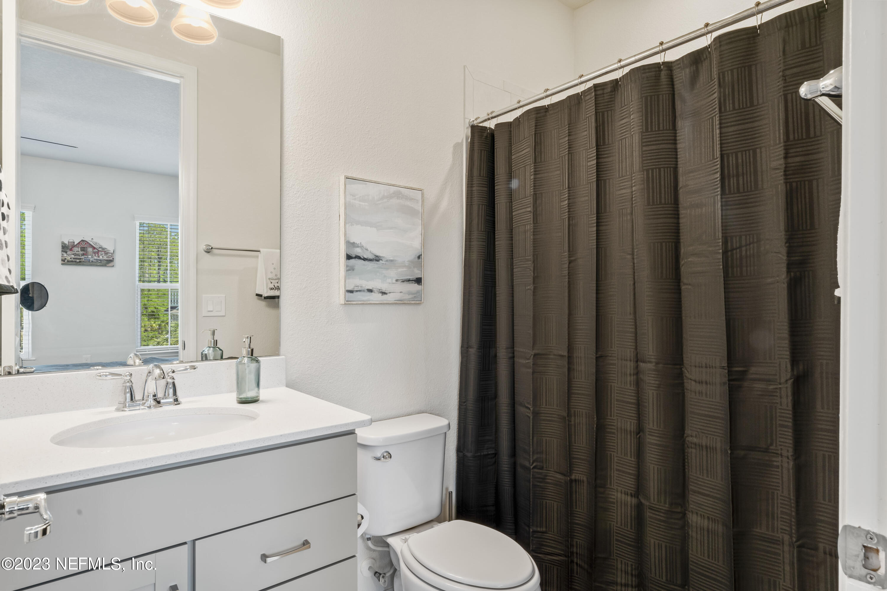 55 Spring Tide Way Ponte Vedra, FL 32081 - Photo 40 of 75 a bathroom with a sink a toilet a mirror and shower curtain