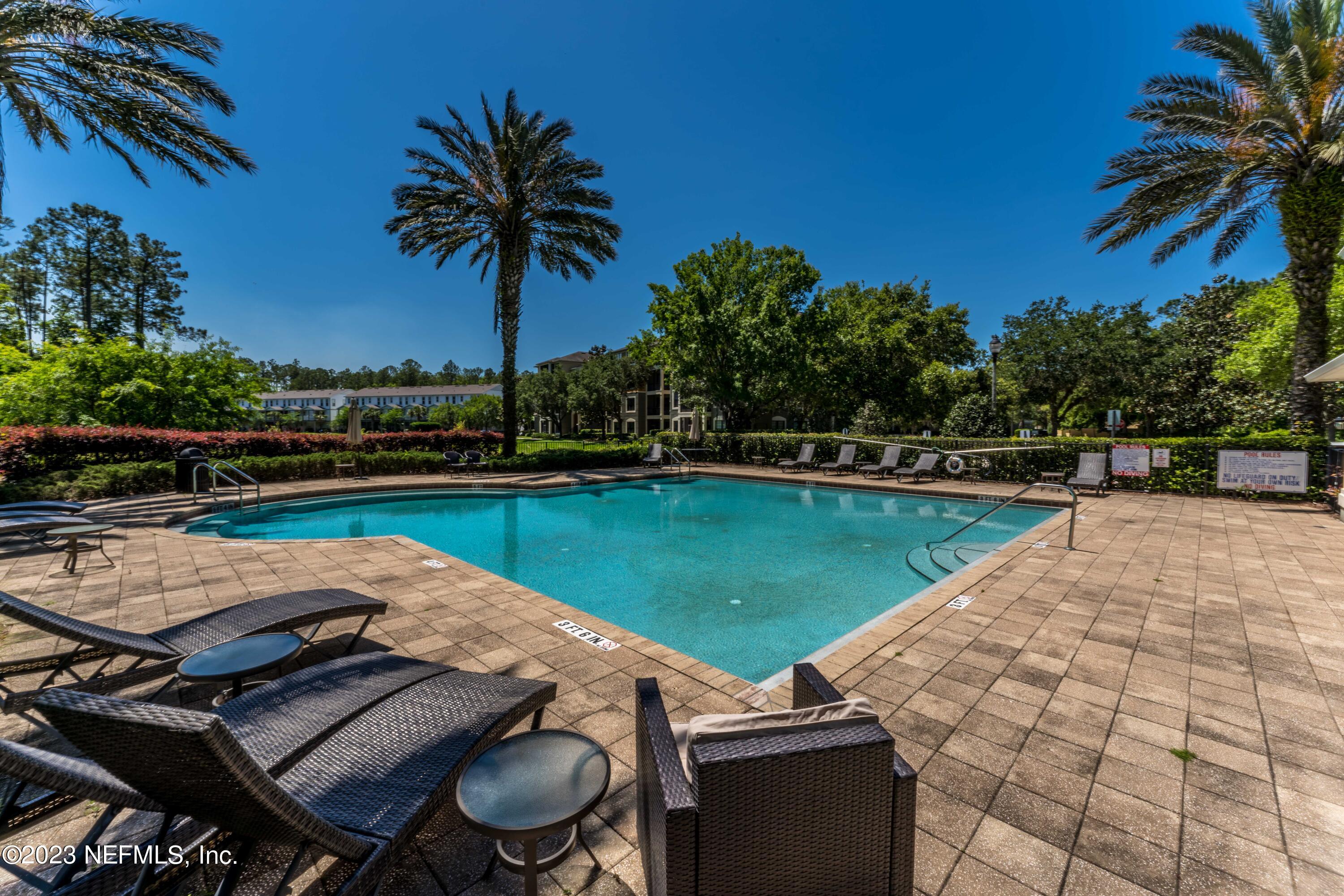 55 Spring Tide Way Ponte Vedra, FL 32081 - Photo 57 of 75 a view of a swimming pool with a table and chairs under an umbrella
