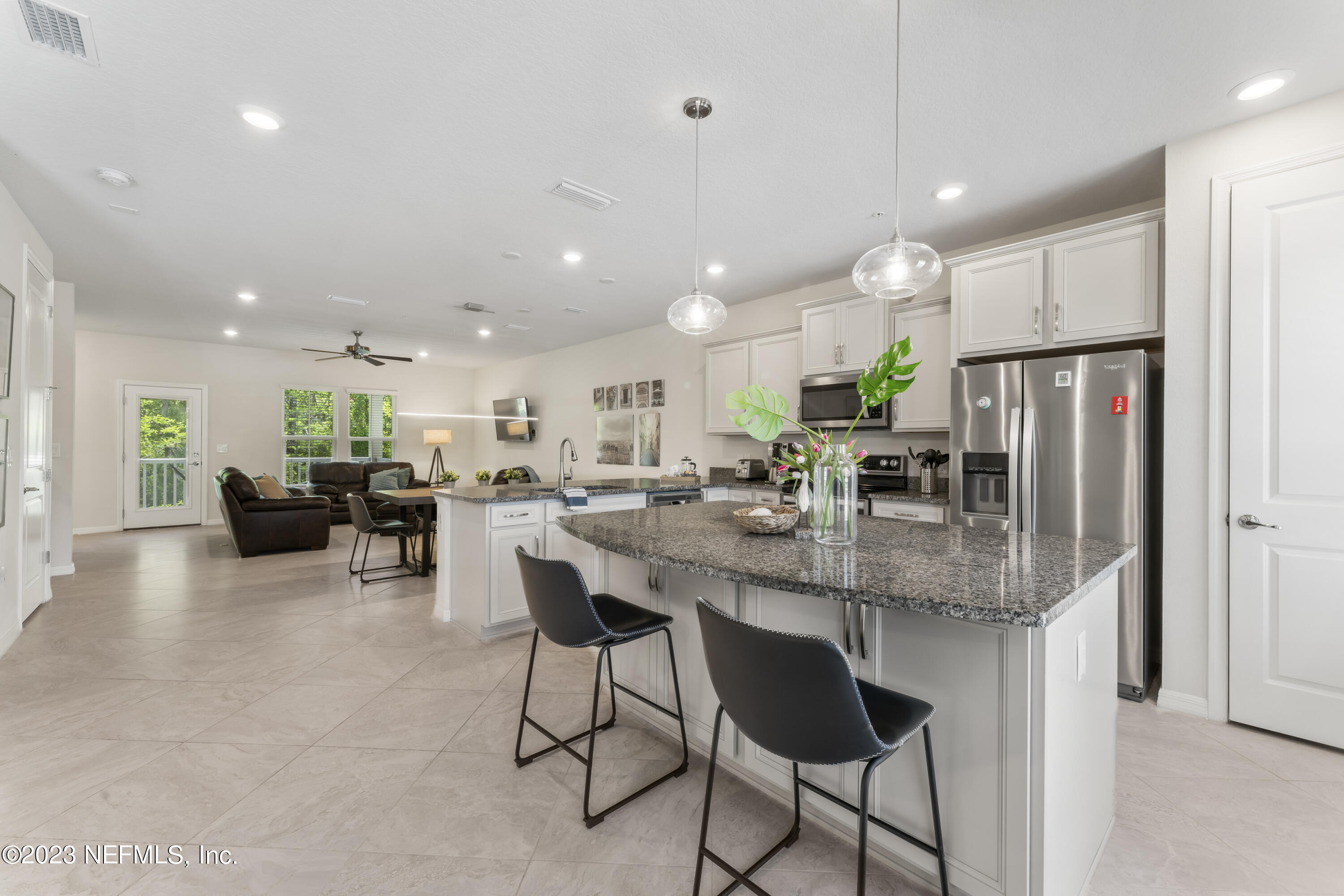 55 Spring Tide Way Ponte Vedra, FL 32081 - Photo 9 of 75 a kitchen with stainless steel appliances kitchen island granite countertop a dining table chairs refrigerator and microwave