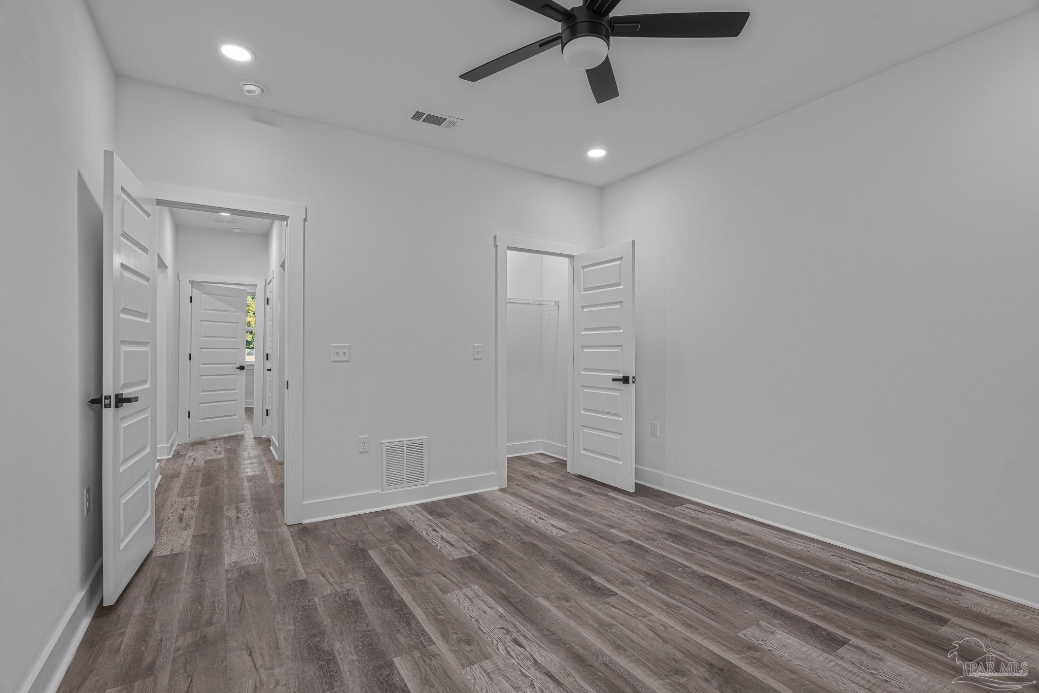 5005 Saufley Field Road Pensacola, FL 32526 - Photo 18 of 27 an empty room with wooden floor and a ceiling fan