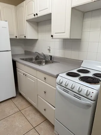a kitchen with granite countertop white cabinets and white appliances