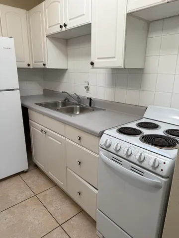 a kitchen with granite countertop white cabinets and white appliances
