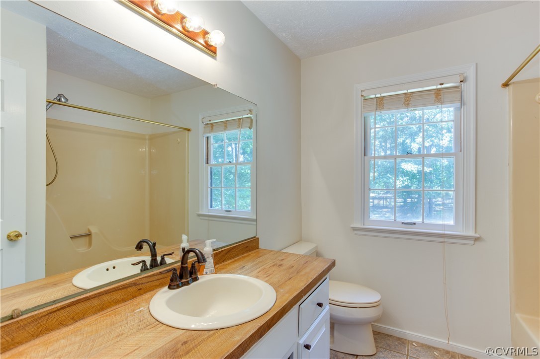 7460 Strath Road Henrico, VA 23231 - Photo 20 of 32 a bathroom with a granite countertop sink toilet a mirror and a tub