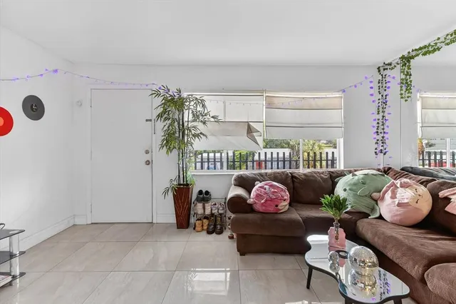 a living room with stainless steel appliances furniture and a kitchen view